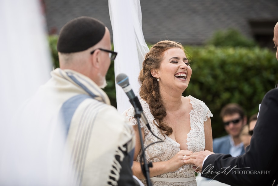 bride laughs with joy as groom puts her ring on her hand - brazil room wedding - tilden park - berkeley wedding