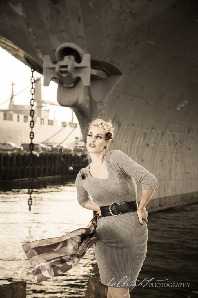 Photo of model in vintage dress posing in front of the U.S.S. Hornet Aircraft Carrier in Alameda, CA