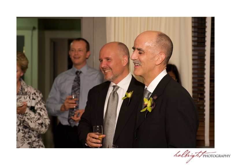 Grooms wearing dark suits and holding champagne for a toast | San Francisco Wedding - LGBT Wedding