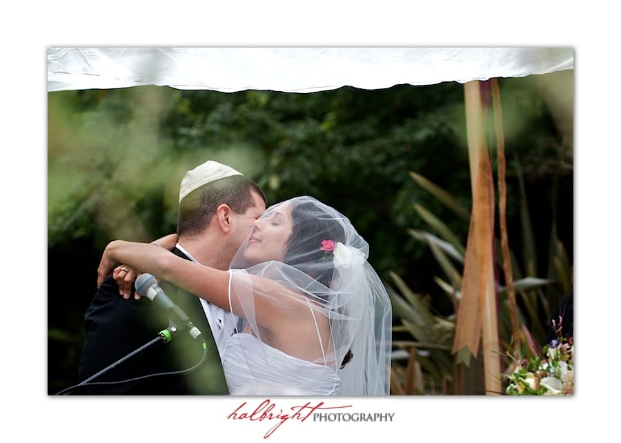 Bride embraces the groom under the chuppah - bodega bay secret gardens - marin wedding