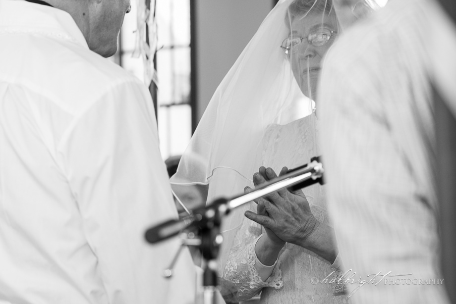 Bride puts her hands together as if to pray during the wedding ceremony