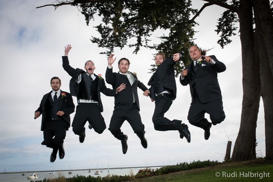 Groom and groomsmen jump up in the air with the ocean behind them - half moon bay wedding - bay area wedding - photographer