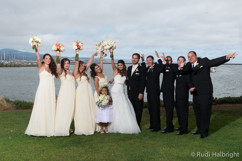 bridal party portrait - bridesmaids raise their arms and bouquets up in the air - half moon bay - mavericks - wedding