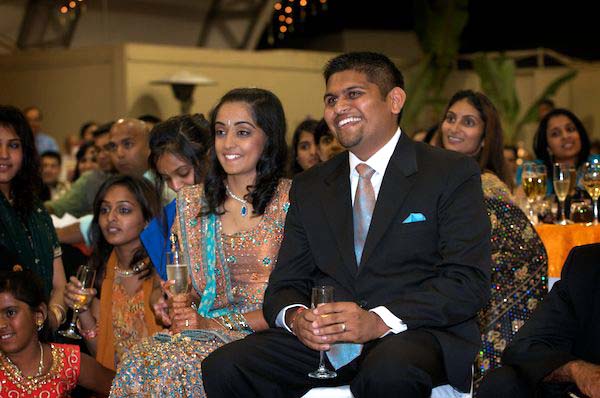 Indian Bride and Groom sit together as guests entertain them - Gilroy Gardens Wedding